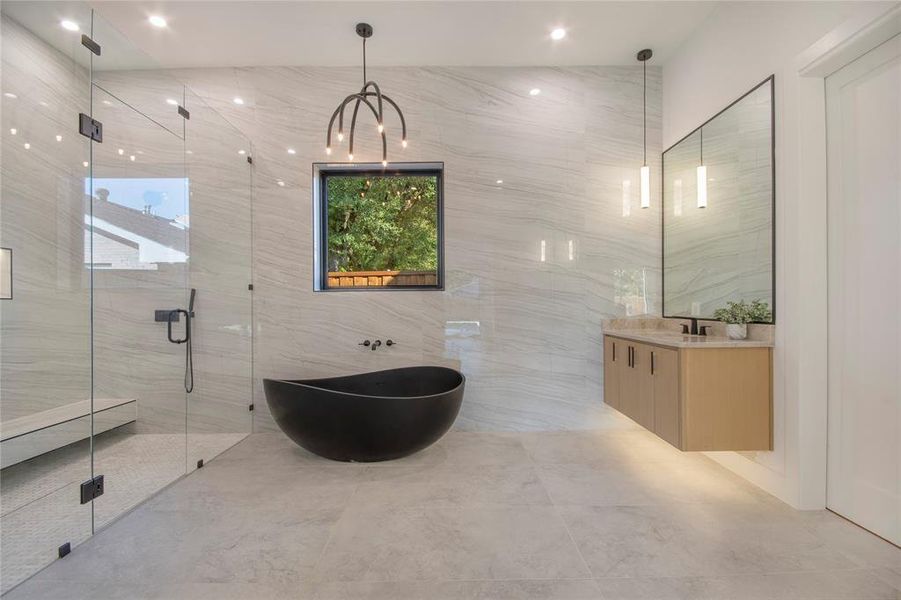 Full bathroom featuring a freestanding tub, vanity, tile walls, and a marble finish shower