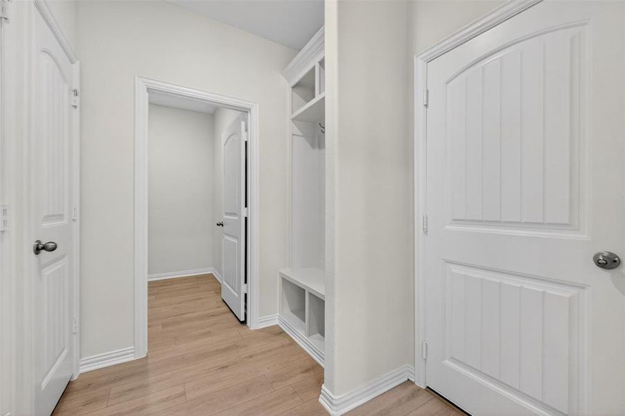 Mudroom featuring light wood-style floors and baseboards