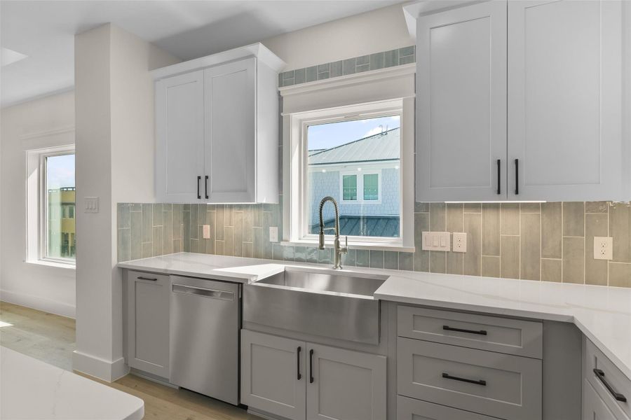 Enjoy serene bay views from the spacious apron sink in this beautifully appointed kitchen. Enjoy serene bay views from the spacious apron sink in this beautifully appointed kitchen.