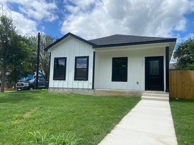 A newly constructed residence features crisp white siding and dark trim, highlighted by a welcoming concrete pathway. A newly constructed residence features crisp white siding and dark trim, highlighted by a welcoming concrete pathway.