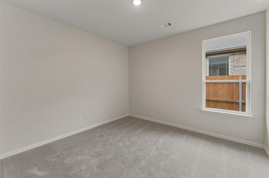 Light gray carpeted room with white baseboards and a recessed ceiling light