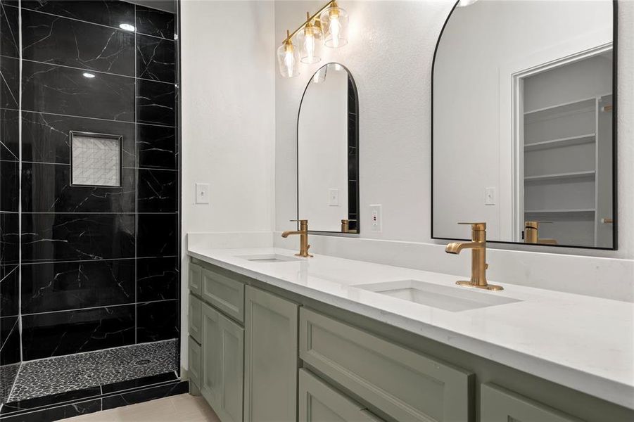 Bathroom with vanity and tiled shower