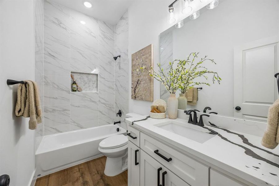 Bathroom featuring a white vanity with a sink and a tub-shower combo