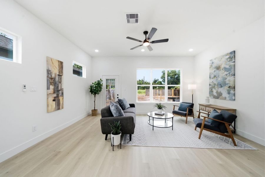 The living room offers direct access to the large backyard with large windows bringing in natural light.