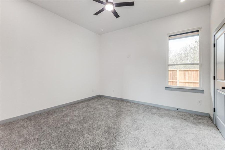 Empty room featuring carpet floors and ceiling fan