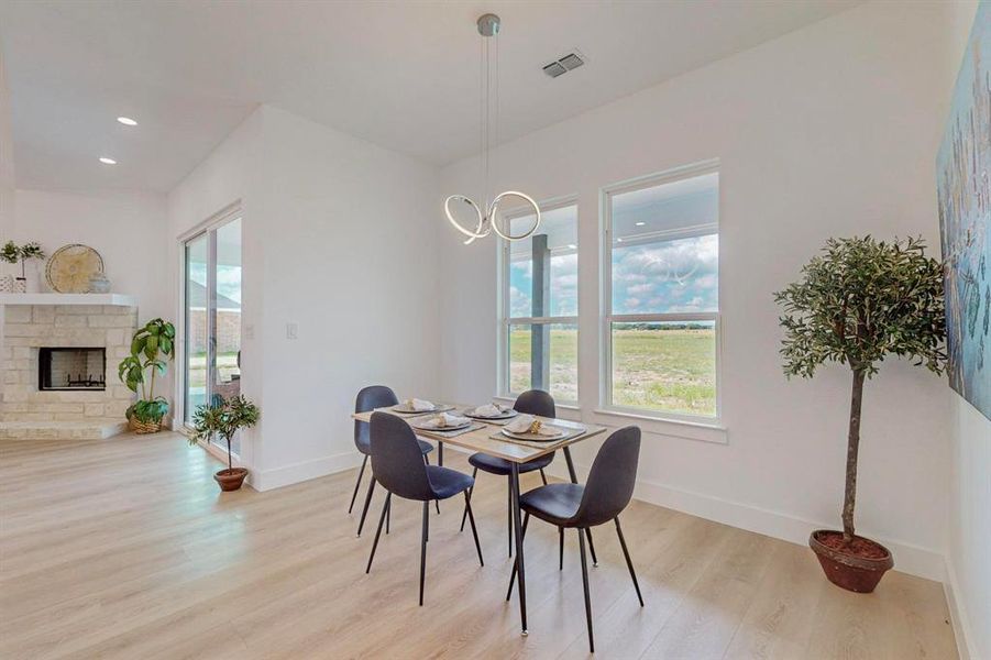 Dining space featuring plenty of natural light, light hardwood / wood-style floors, and a fireplace