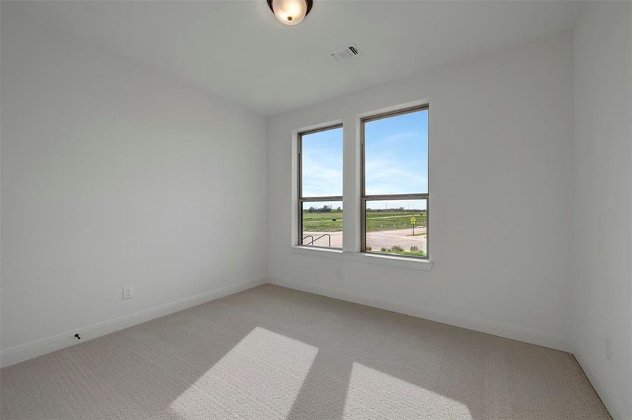 Empty room featuring light colored carpet and baseboards