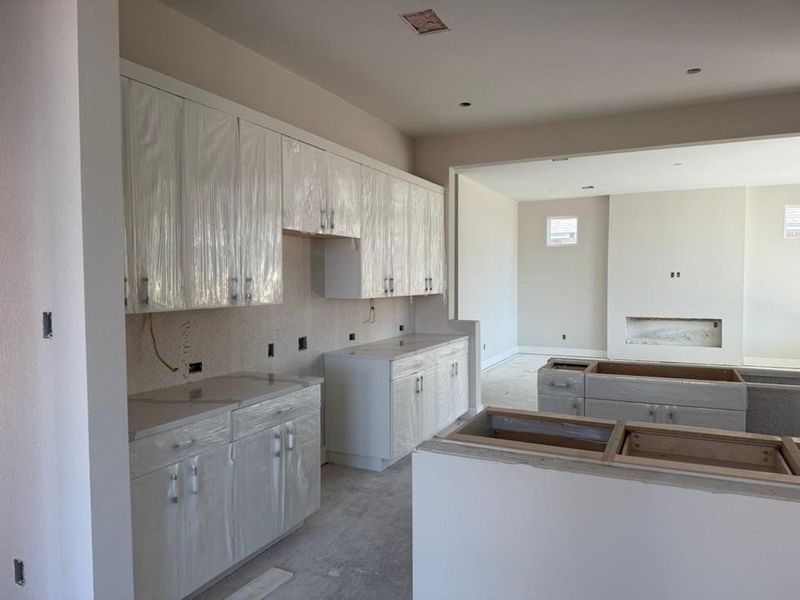 Kitchen with tasteful backsplash, a kitchen island, and white cabinetry