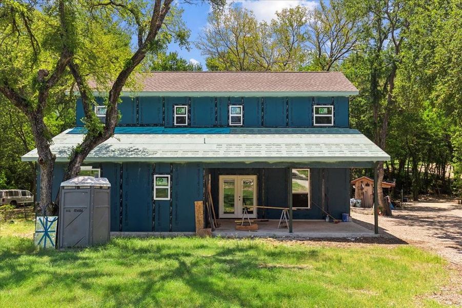 Front view of property featuring french doors and a yard