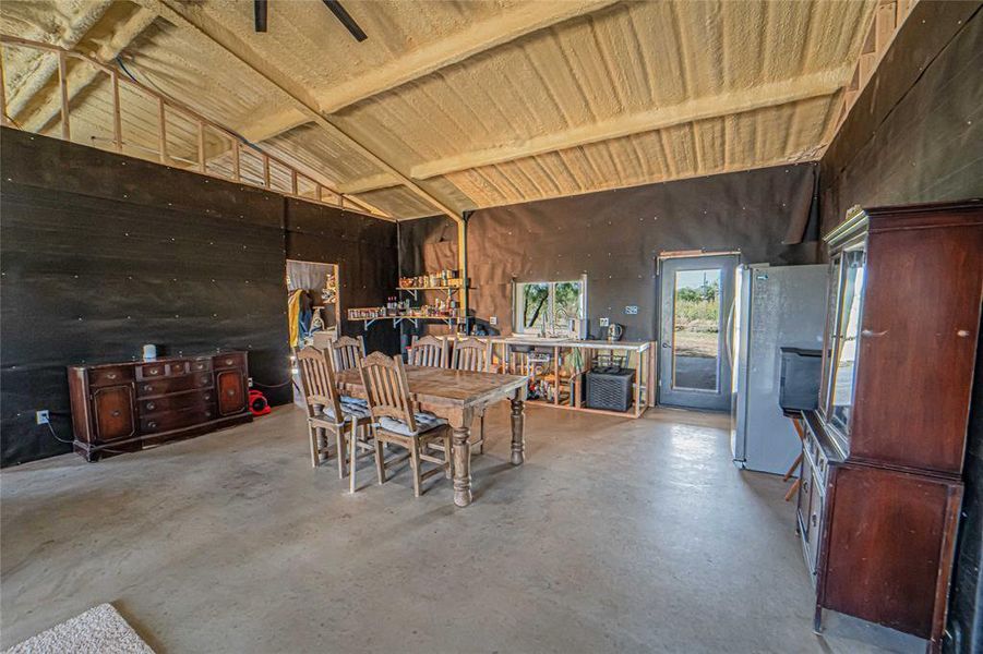 Dining space with concrete flooring and a workshop area