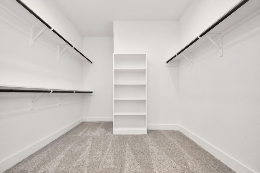 Walk-in closet that epitomizes luxury and practicality. This generously sized space features built-in shelving, offering abundant room for impeccable organization. High ceilings and recessed lighting create a bright and welcoming ambiance. Walk-in closet that epitomizes luxury and practicality. This generously sized space features built-in shelving, offering abundant room for impeccable organization. High ceilings and recessed lighting create a bright and welcoming ambiance.