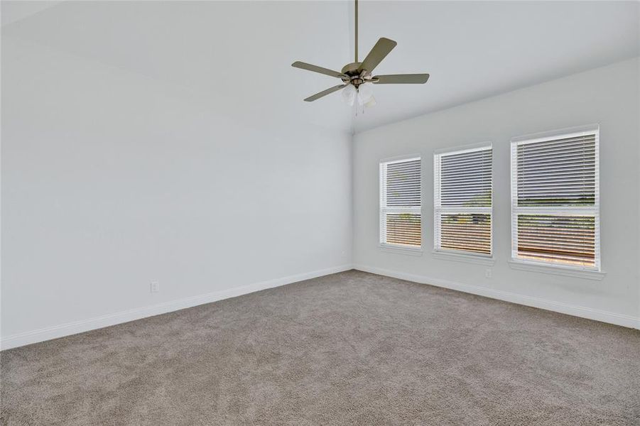 Spare room with carpet, ceiling fan, and lofted ceiling