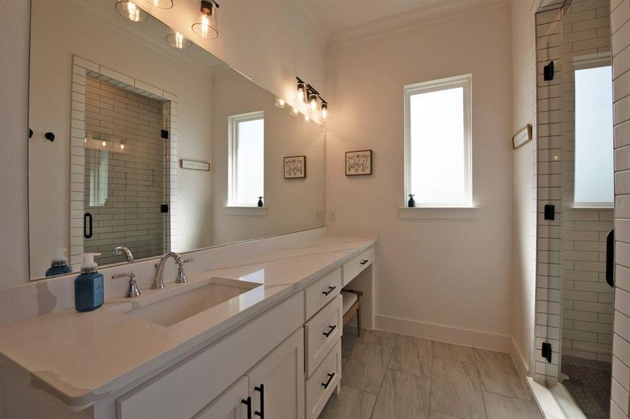 Full bathroom with vanity, a stall shower, and crown molding