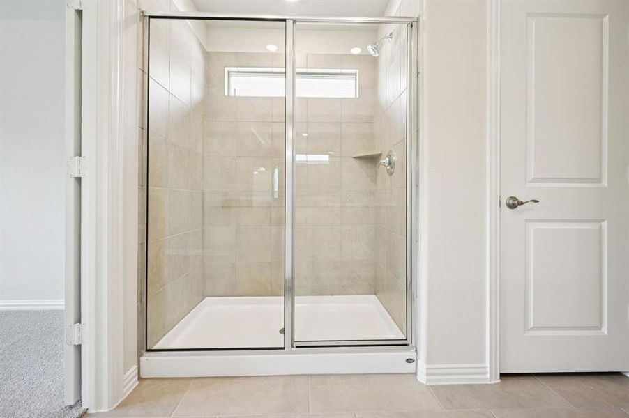 Full bathroom with a shower stall and tile patterned floors