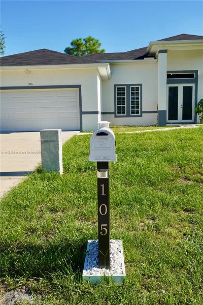 Front exterior of a new home in , Lehigh Acres, FL, highlighting curb appeal (Image 29).