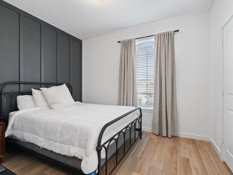 Bedroom with multiple windows and light hardwood / wood-style flooring