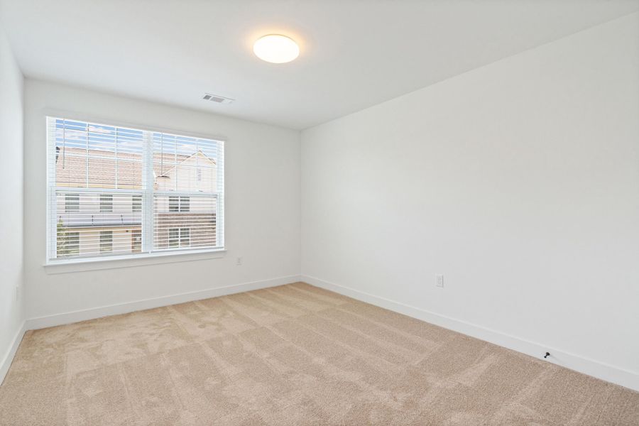 Room featuring neutral tone carpeting and crisp white walls Room featuring neutral tone carpeting and crisp white walls