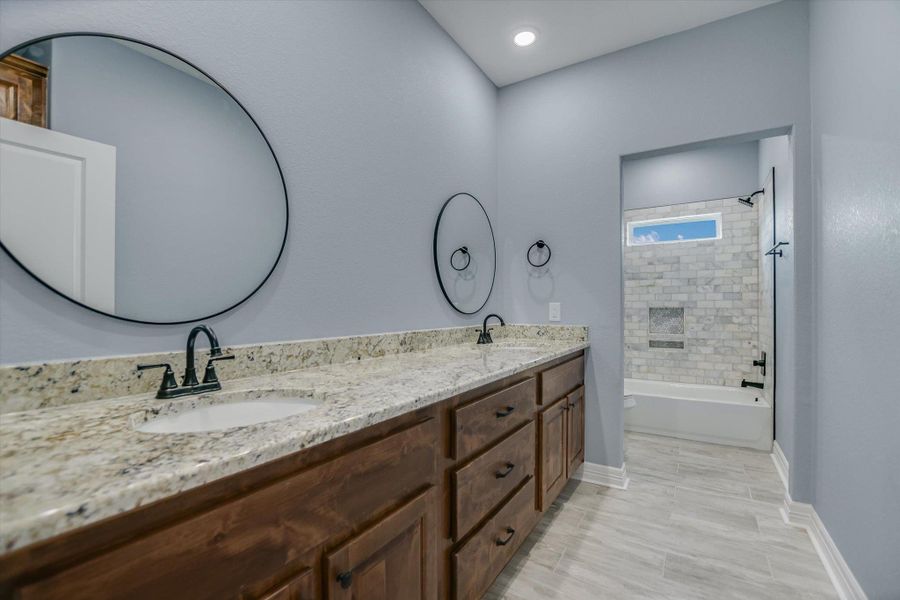 Full bath with double vanity and bathing tub / shower combination