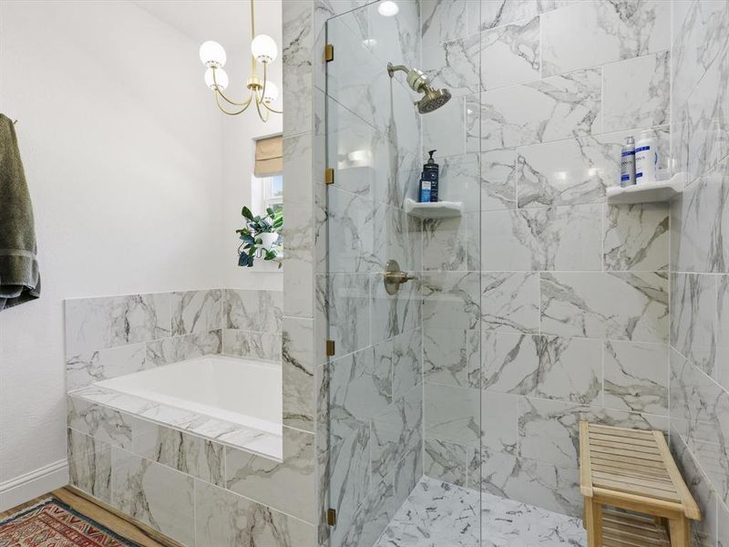 Full bathroom featuring a garden tub, a marble finish shower, and wood finished floors