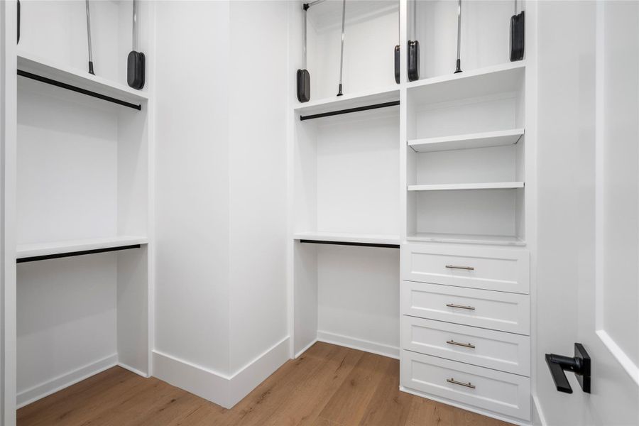 Spacious second primary closet with built-in shelving, abundant hanging space, and storage drawers designed for effortless organization. Spacious second primary closet with built-in shelving, abundant hanging space, and storage drawers designed for effortless organization.
