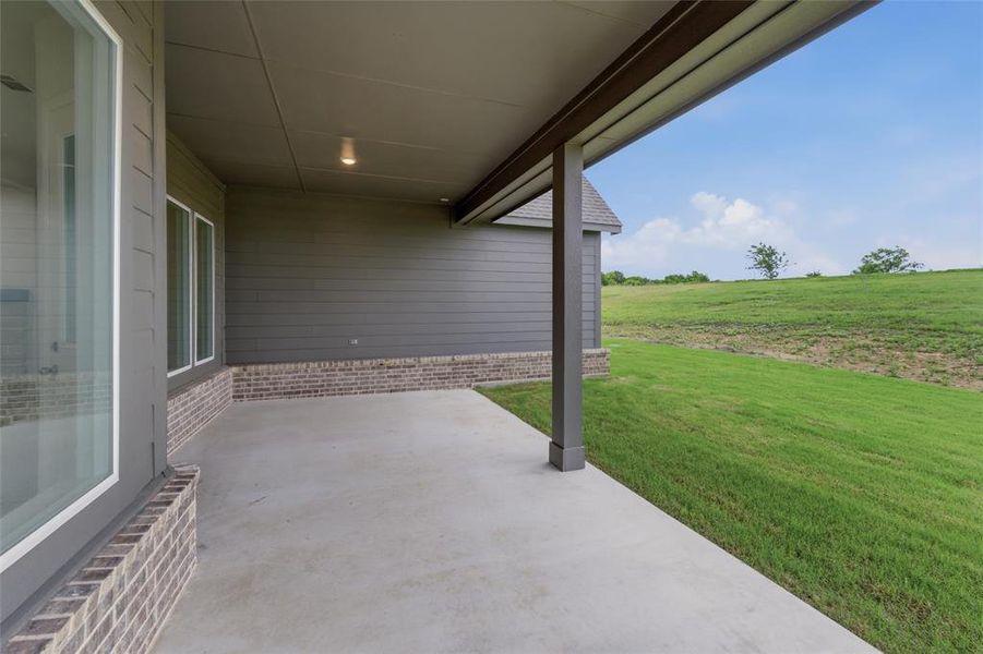 Concrete patio with a dark grey column and matching overhead structure