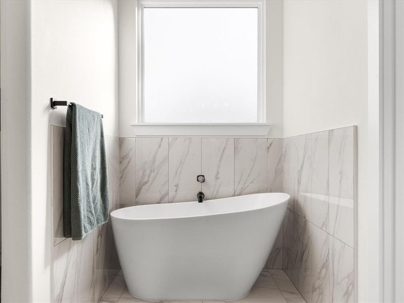 Bathroom with tile walls and a soaking tub