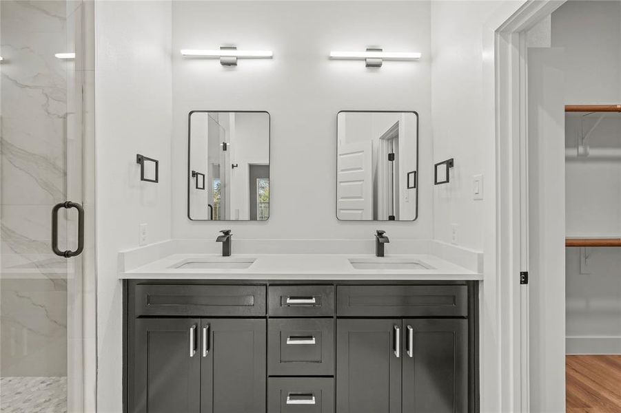 Bathroom featuring hardwood / wood-style floors, vanity, and a shower with door