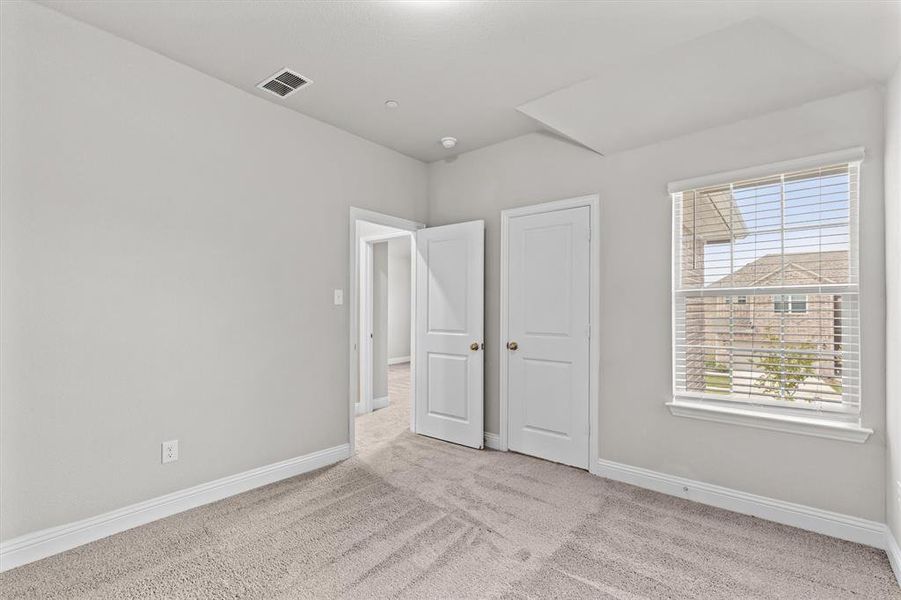 Unfurnished bedroom with light colored carpet