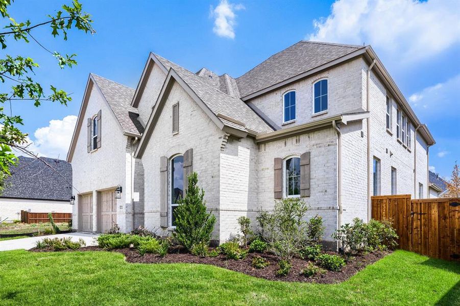 White brick exterior featuring a multi-gabled roofline and dark wood-look shutters White brick exterior featuring a multi-gabled roofline and dark wood-look shutters
