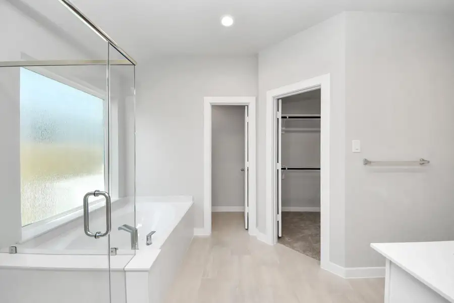 Indulge in a spa-like retreat within the confines of this primary bathroom. Delight in a spacious walk-in shower enveloped in stylish tile surround and unwind in a separate garden tub adorned with custom detailing. Sample photo of completed home with similar floor plan. Actual colors and selections may vary. Indulge in a spa-like retreat within the confines of this primary bathroom. Delight in a spacious walk-in shower enveloped in stylish tile surround and unwind in a separate garden tub adorned with custom detailing. Sample photo of completed home with similar floor plan. Actual colors and selections may vary.