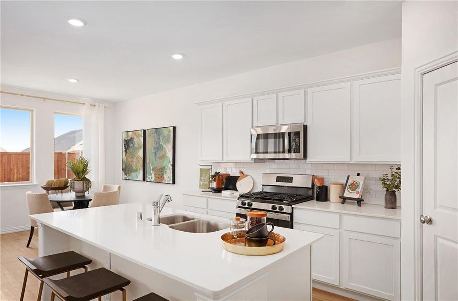 Kitchen with white cabinetry, sink, and appliances with stainless steel finishes