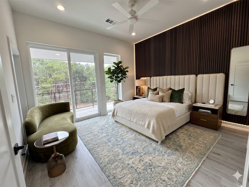 This modern bedroom features a stylish accent wall, large windows with natural views, and a cozy seating area. The room is elegantly furnished with a plush bed, bedside tables, and a decorative rug, offering a serene and inviting atmosphere.