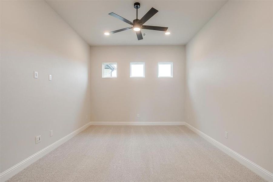 Carpeted spare room featuring ceiling fan