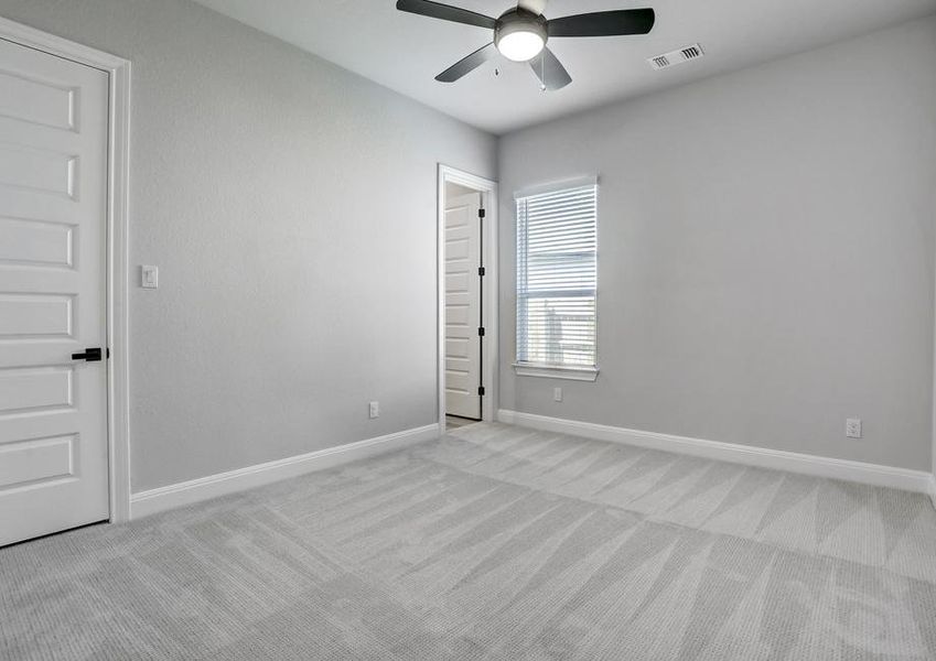 Secondary bedroom with a ceiling fan, window, and walk-in closet.