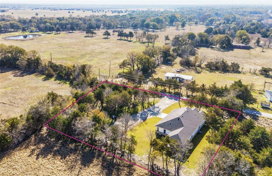 Aerial view of sparsely populated area featuring property parcel outlined