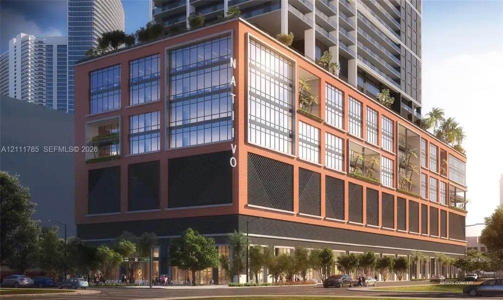 Industrial-inspired architecture featuring red brick facade, floor-to-ceiling glass windows, recessed private balconies, and geometric metal screening