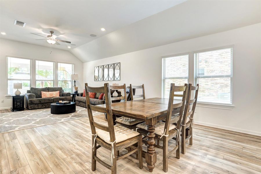 Dining space with light wood-style floors, healthy amount of natural light, ceiling fan, vaulted ceiling, and recessed lighting