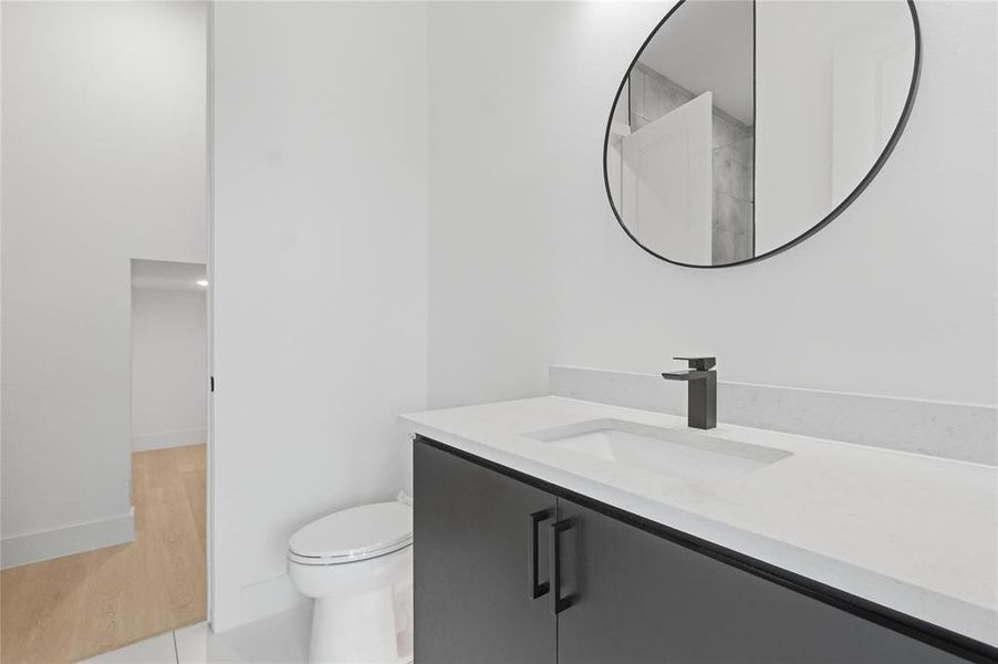 Modern vanity featuring a single integrated sink, light-toned countertop, and matte black faucet Modern vanity featuring a single integrated sink, light-toned countertop, and matte black faucet