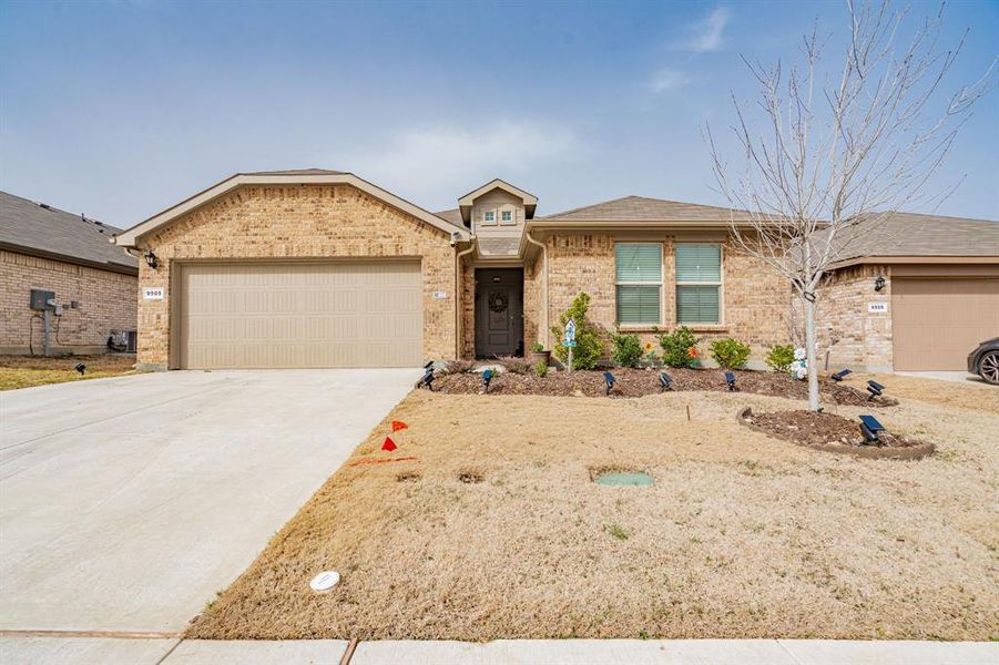 Single story home with brick siding, concrete driveway, and an attached garage