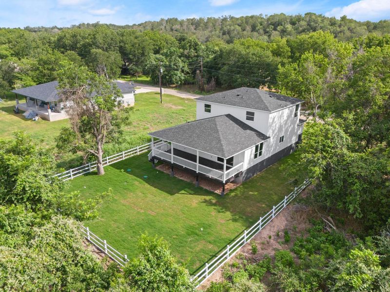 Aerial view of property and surrounding area with a heavily wooded area