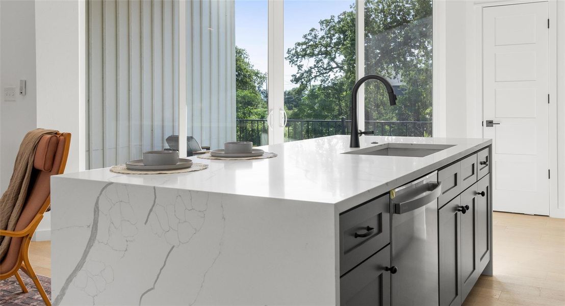 A quartz island bathed in natural light, ready for morning coffee, a shared meal, or a glass of wine with friends. Model No. 105 Shown.