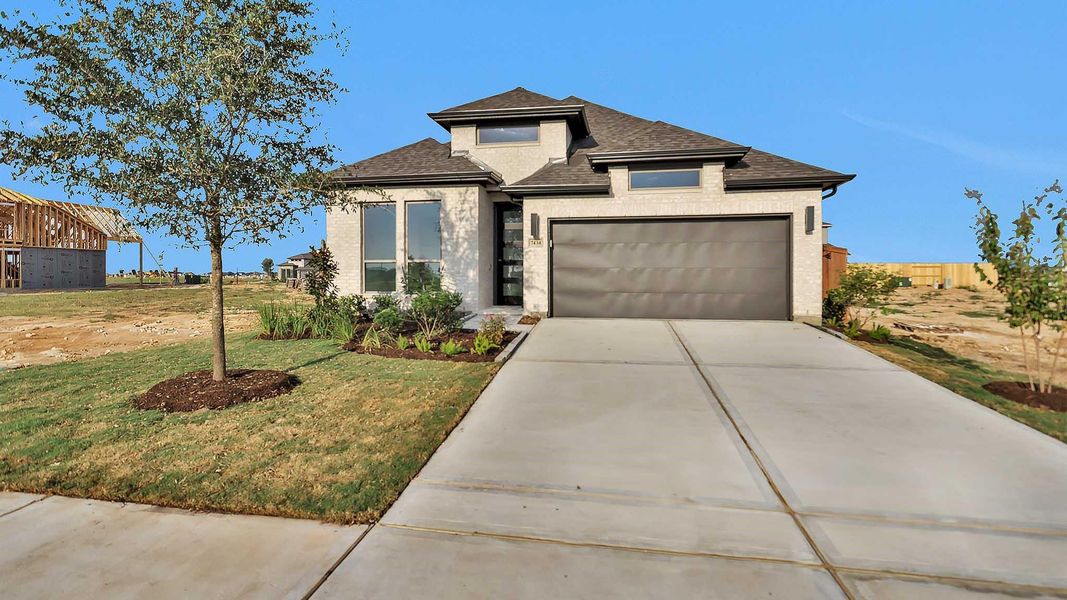 Front exterior of a new home in Elyson 45', Katy, TX, highlighting curb appeal (Image 2). Front exterior of a new home in Elyson 45', Katy, TX, highlighting curb appeal (Image 2).