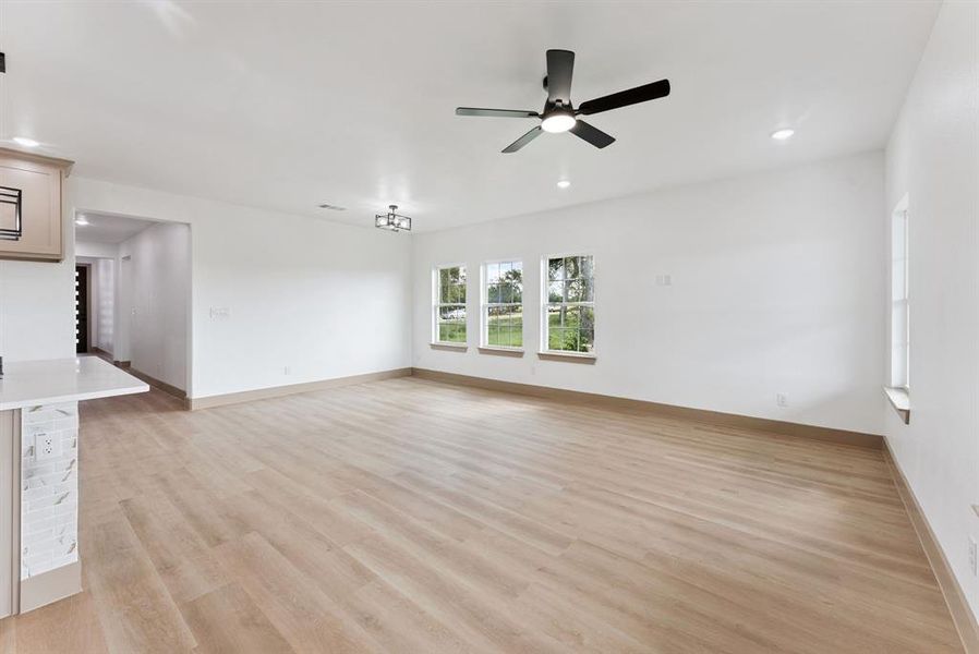 Unfurnished living room with light wood-style floors, recessed lighting, and ceiling fan Unfurnished living room with light wood-style floors, recessed lighting, and ceiling fan