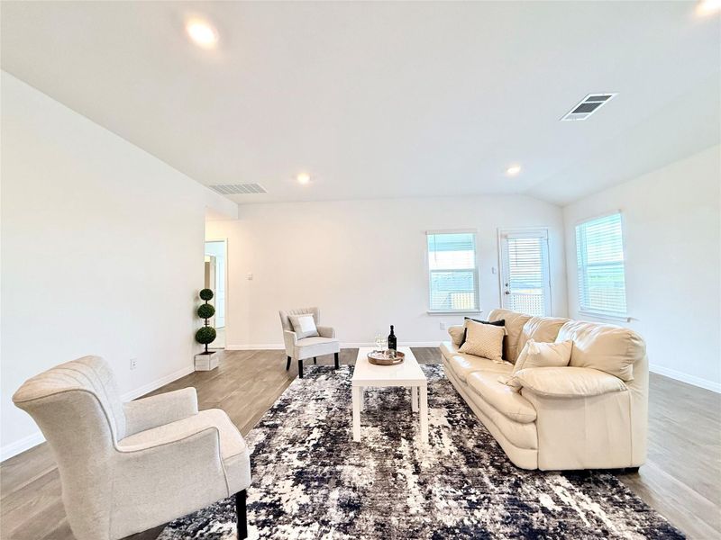 Living area featuring light wood-style floors, recessed lighting, and lofted ceiling Living area featuring light wood-style floors, recessed lighting, and lofted ceiling