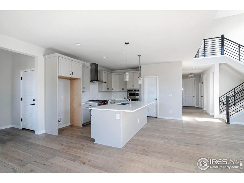 Kitchen open to the living space and  dining area. Note the mudroom just off of the kitchen