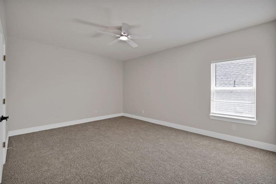 Empty room featuring carpet, ceiling fan, and baseboards Empty room featuring carpet, ceiling fan, and baseboards