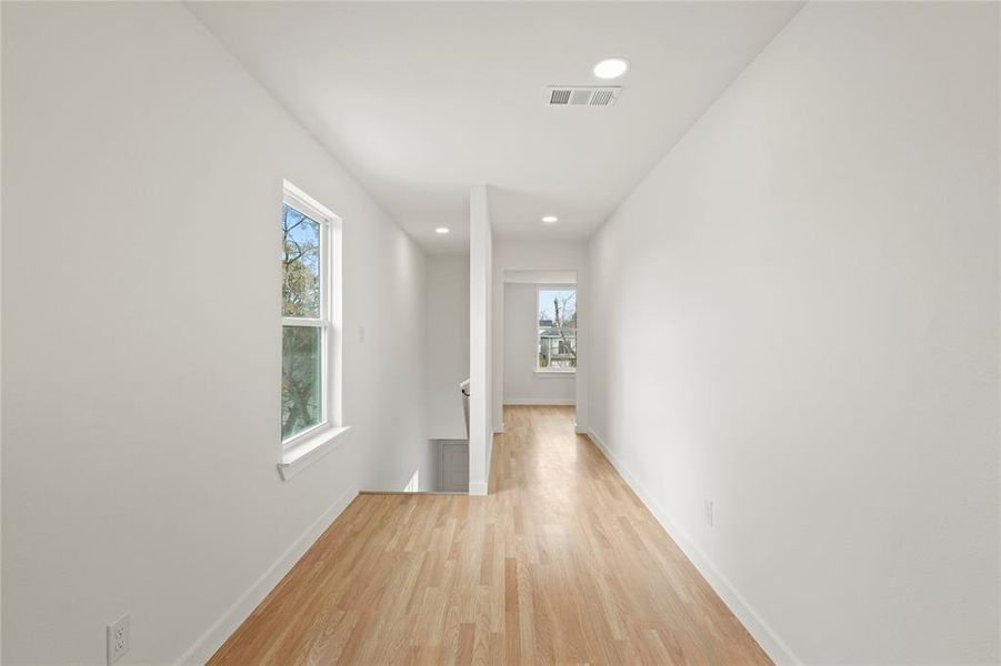 Corridor featuring plenty of natural light and light hardwood / wood-style flooring