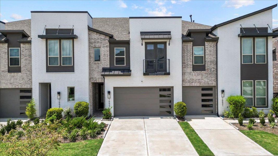 Contemporary house with brick siding, a balcony, a standing seam roof, driveway, and a shingled roof Contemporary house with brick siding, a balcony, a standing seam roof, driveway, and a shingled roof