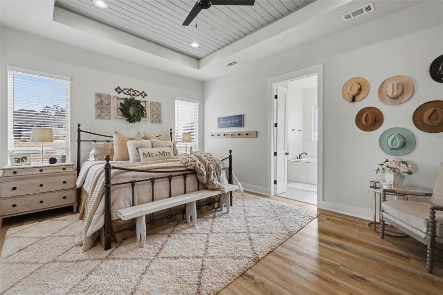 Primary bedroom with wooden ceiling, a raised ceiling, light wood-type flooring, a ceiling fan, and recessed lighting