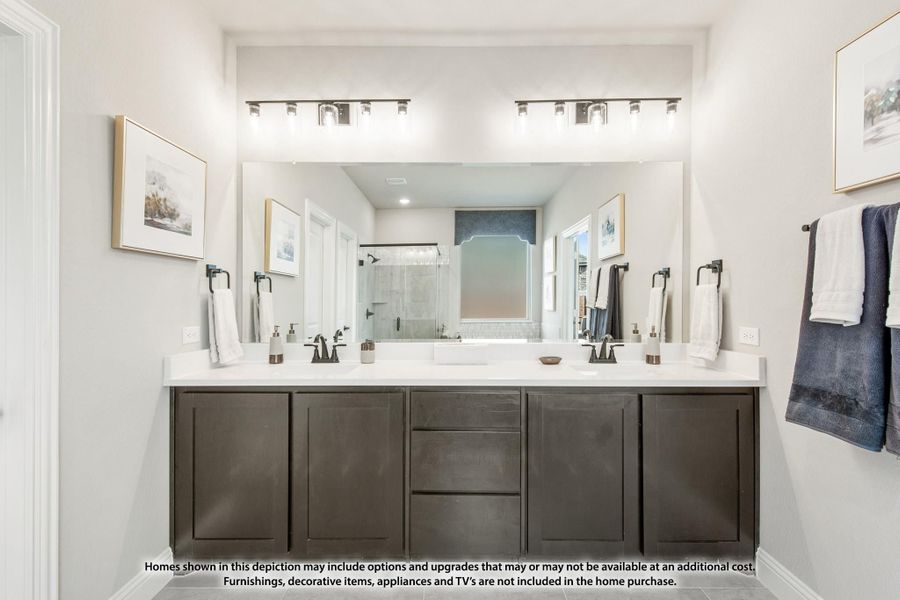 Bathroom with double vanity, dark cabinets, white countertops, large mirror, and glass shower in background. Bathroom with double vanity, dark cabinets, white countertops, large mirror, and glass shower in background.